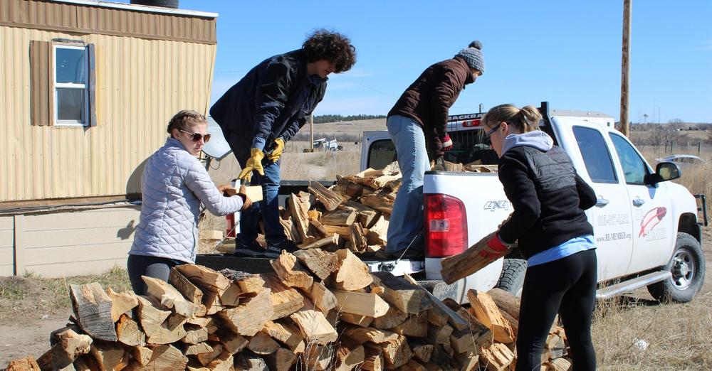 volunteers cutting firewood
