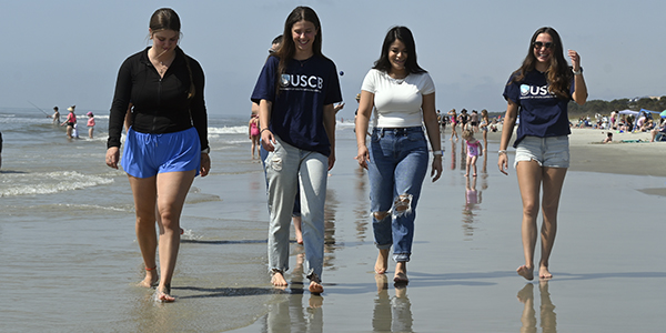 students walking on a beach students walking on a beach