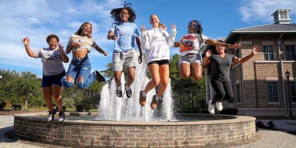 Students Happy by Fountain students jumping in front of a fountain
