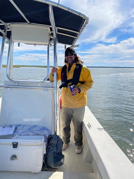  USCB’s Dr. Eric Montie and his dolphin research are featured in a new video produced by the Port Royal Sound Foundation. In it, Montie explains what he does, why he loves it and why his research is important.   In the film, viewers accompany Dr. Eric Montie and his lab assistant Alyssa Marian on a dolphin survey trip on the May River in Bluffton, SC. As they make their way by boat from the mouth of the river to its headwaters near Palmetto Bluff, they count the number of dolphins they see, photograph them and identify individual dolphins by the unique markings on their dorsal fins. After years of research, the scientists are able to distinguish between resident and migrating dolphins.   Keeping tabs on the dolphin population through surveys is important because dolphins are apex predators.  “The more dolphins we have in an estuary, most likely the healthier the estuary —meaning that there’s more prey that these animals can feed on,” Montie said.  His research includes collecting recordings of estuary soundscapes from nine recorders placed in four different estuaries throughout South Carolina. The devices are listening to snapping shrimp and fish species such as black drum, red drum and spotted sea trout. The recorders also pick up the sounds that bottlenose dolphins make.   Montie, Marian and some of Montie’s advanced undergraduate students study the recordings to learn more about the relationships between prey and predator. The recorders also pick up other noises such as boat activity. These soundscape recordings are especially useful to scientists working in areas where visibility is limited, such as Bluffton’s May River.  “Dolphins sort of act as canaries in the coal mines,” Montie says in the video. “If the system isn’t doing well, their populations may drop.   Montie is an Associate Professor of Biology in USCB’s Department of Natural Sciences. He is director of the University’s Marine Sensory & Neurobiology Lab.  Port Royal Sound Foundation Executive Director Jody Hayward said the non-profit organization produced the video as a tool for educating the community about the local environment, promoting STEAM careers, and preserving the Port Royal Sound.   “A special thank you to Eric Montie and Alyssa Marian for offering their time and expertise, and to PRSF’s Kat Armstrong and Harden Creative for putting this production together,” she said.  Watch the video: https://www.youtube.com/watch?v=wEyhcoql0Ss    Bottlenose dolphins in May River. Photo by L. Transue      Dr. Eric Montie, PhD, Associate Professor of Biology in the Department of Natural Sciences at USCB, is Director of the Marine Sensory and Neurobiology Lab and The Lowcountry Dolphin Conservation Program.