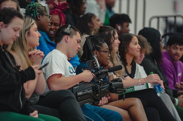 Students filming under the basket