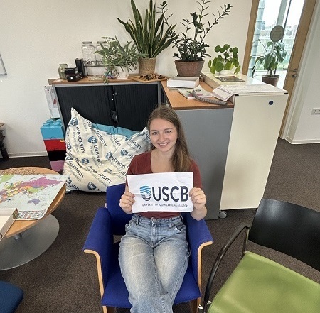 Student holding USCB sign in chair