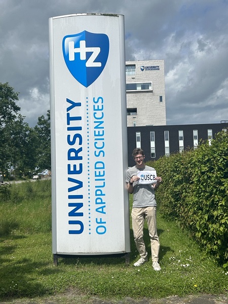 Student holding USCB sign next to HZ University