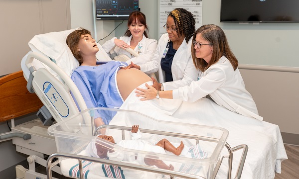 Nursing students working with pregnancy manikin