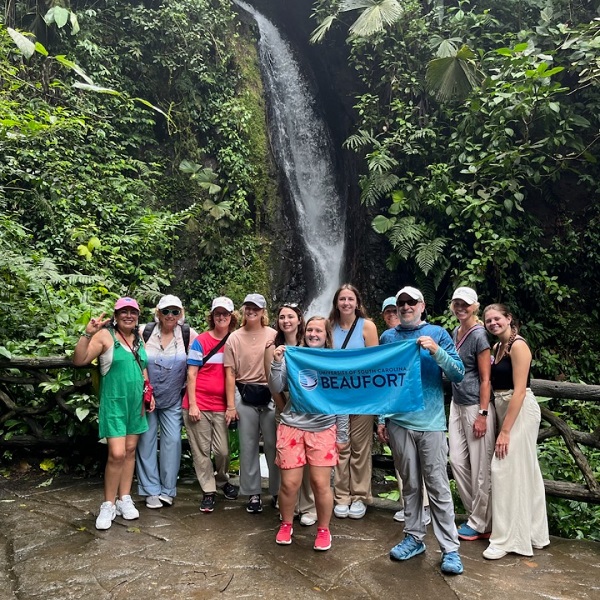 Students from USCB on a hike with a USCB flag