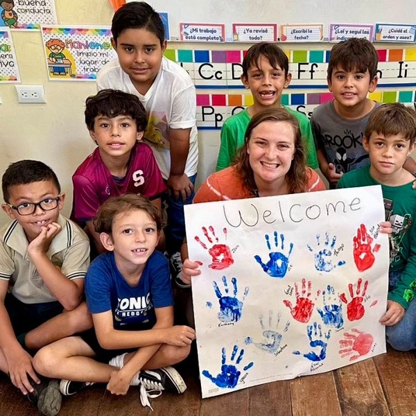 Student teacher from USCB with Costa Rica students and their handmade sign