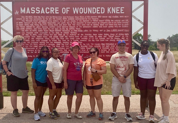 Group picture in front of sign