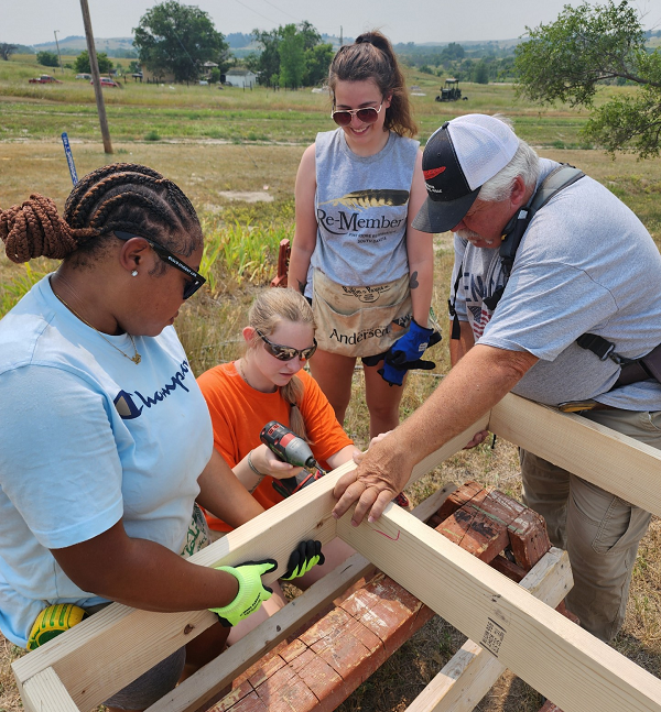 Volunteers drilling into wood structure