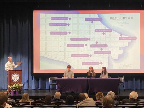 Dr. James Shinn introducing students Samantha Mischke, Grace Farish and unnamed classmate