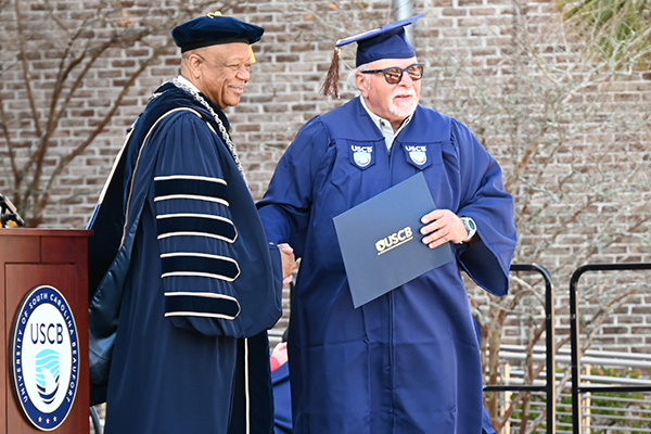 Ben Blumenfield accepting his degree with Chancellor Al Panu