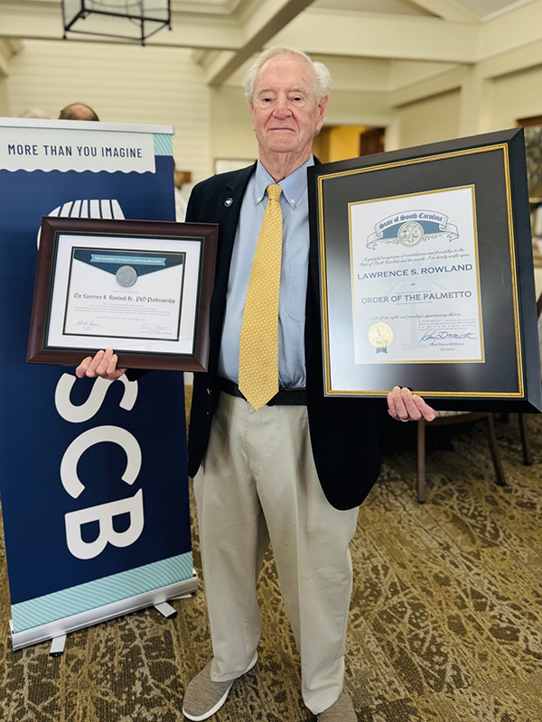 Dr. Larry Rowland Holds His Awards